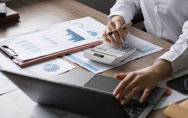 istock Young Businesswoman Analyzing Financial Documents and Data at Modern Office Desk with Laptop and Calculator 2181694501