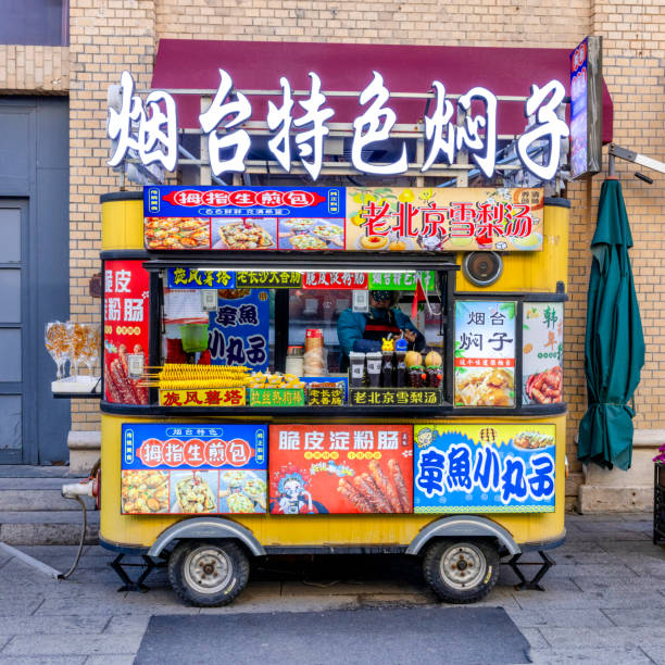 Yantai, China - March 1st, 2024: A colorful street food cart in Yantai offers a variety of local snacks and delicacies. The vibrant signs and decorations attract passersby, showcasing the lively street food culture of the area.