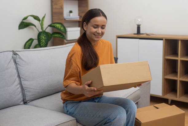 istock With package in hand, woman at home happy with her online purchase, highlighting ease of shipping. 2181694792