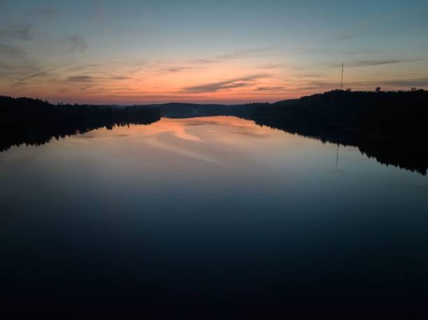 Sunset over a tranquil river reflecting vibrant hues.