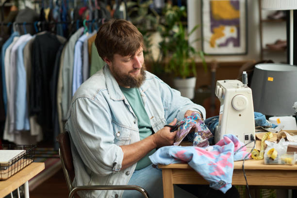 istock Young man cutting out piece of textile 2181696532