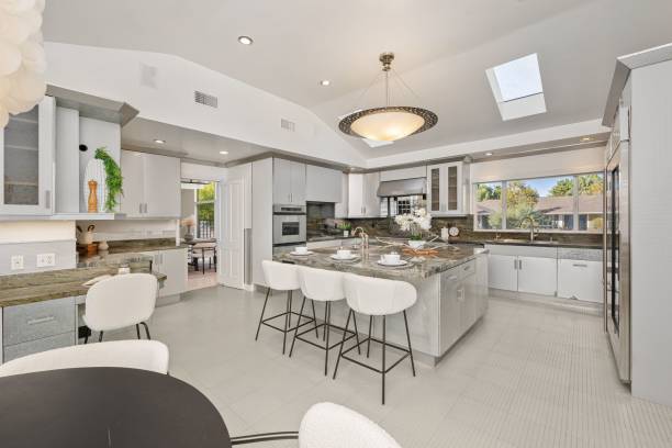 istock Modern kitchen interior with sleek design, with a large island, white cabinetry, and natural light 2181696752
