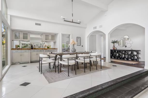 istock Modern dining room with elegant decor, featuring large windows and lush greenery 2181696798