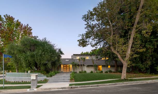 istock Modern residential home surrounded by lush trees and a well-maintained lawn 2181697252
