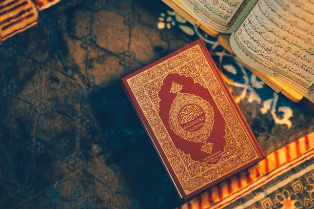 istock beautifully designed religious book rests on textured surface, surrounded by blurred background of additional pages. intricate details of cover and warm colors evoke sense of reverence and 2181697535