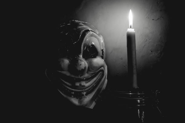 istock Creepy clown mask in a dark room lit by candlelight 2181698026