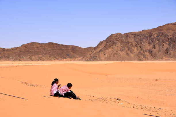 Wadi Rum in Jordan - May 15 2024: people visit old train rails almost completely covered with desert sand