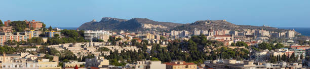 Panoramic view towards the southern city districts of Cagliari. In the distance is the rock formation Sella del Diavolo, and to the center right is the Shrine of Our Lady of Bonaria church.