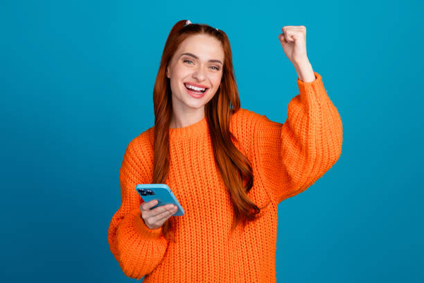 istock Photo of lucky attractive lady dressed knitted pullover winning game modern gadget empty space isolated blue color background 2181703805