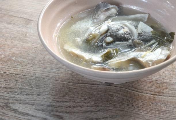 istock boiled bass fish head and slice ginger in plum soup 2181707225