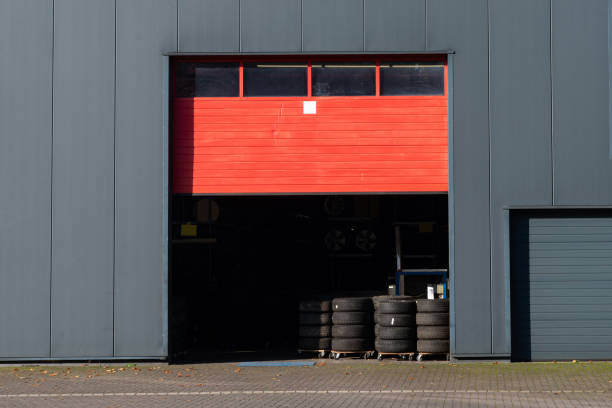 entrée de l’entrepôt avec pneus empilés en plein jour - usine-de-fabrication-de-pneus photos et images de collection