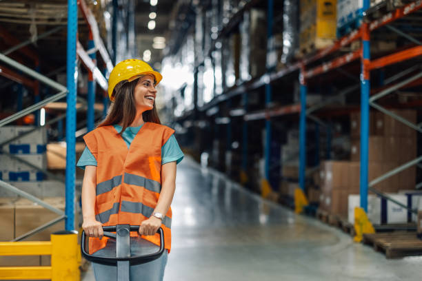 istock Female warehouse worker driving forklift through warehouse 2181711942
