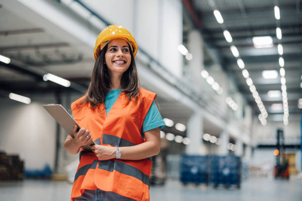 istock Female warehouse worker holding clipboard smiling at camera 2181711947
