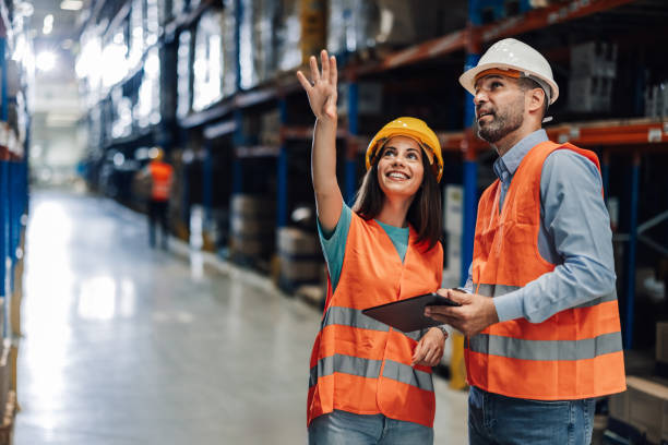 istock Warehouse workers discussing logistics and pointing at storage racks 2181712035