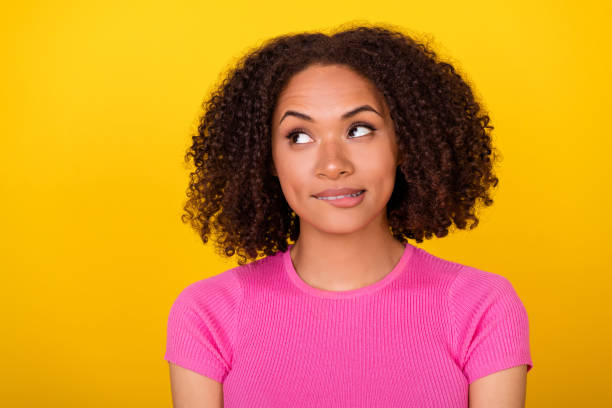 istock Photo of minded young lady biting lips look interested empty space decide isolated on yellow color background 2181715290