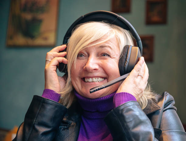 istock Joyful senior woman with headset engaging in virtual communication indoors 2181716093