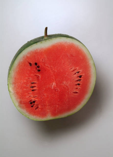 Close up of the inside of a watermelon cut in half, on a neutral background