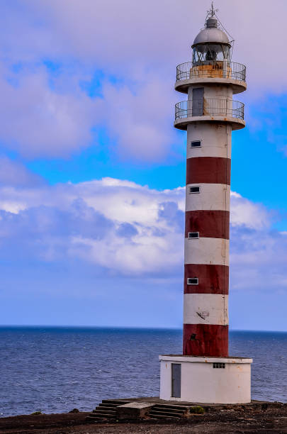 istock A lighthouse is standing on a rocky shoreline, overlooking the ocean 2181717572