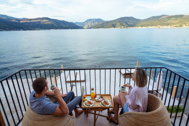 istock Breakfast with a view: couple sharing a meal overlooking the sea 2181719756