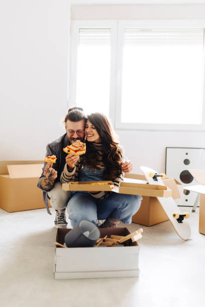 istock Young couple eating pizza in new home 2181723433