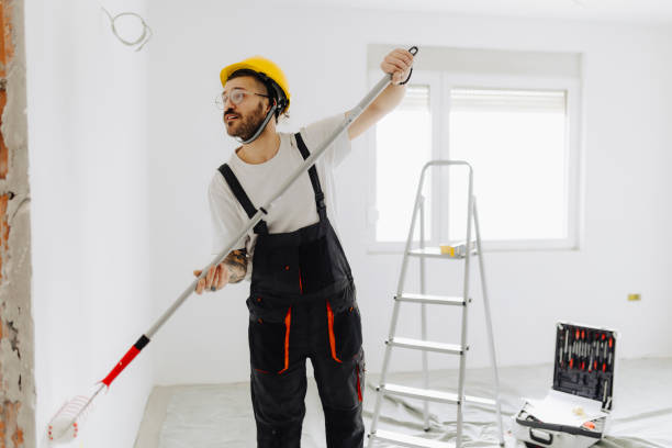 istock Young painter - construction worker painting a wall indoors 2181723675