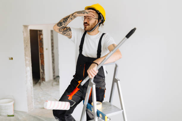 istock Young painter - construction worker painting a wall indoors 2181723790