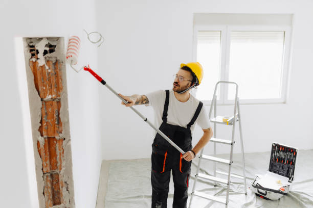 istock Young painter - construction worker painting a wall indoors 2181723799