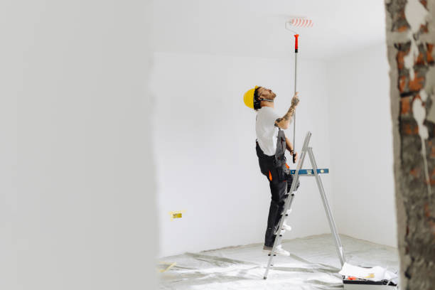 istock Young painter - construction worker painting a wall indoors 2181723950