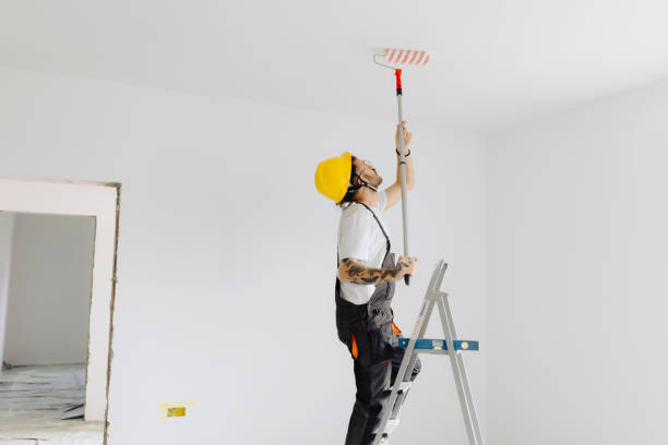 istock Young painter - construction worker painting a wall indoors 2181724009