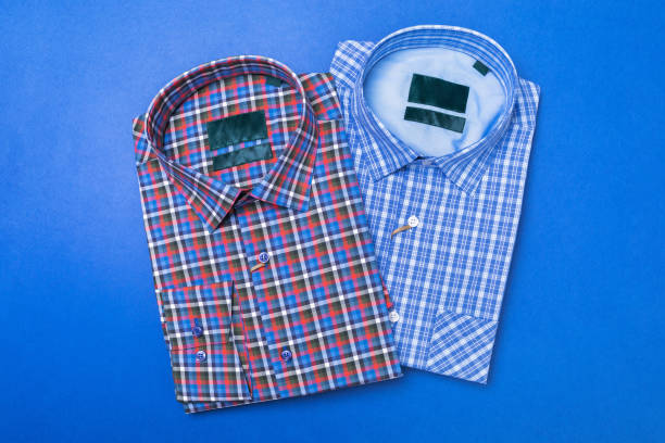 Two checkered shirts in blue and red shades on a blue background, top view
