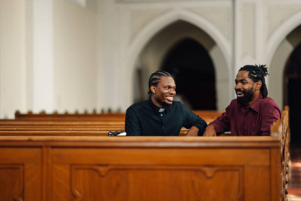 istock Priest smiling and talking with a man in church 2181726524