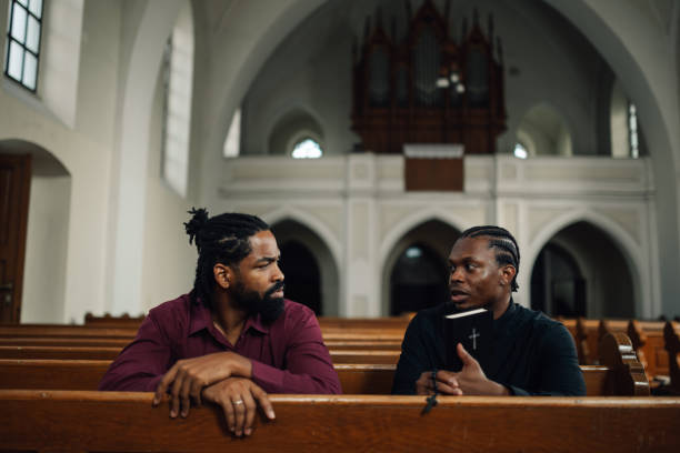 istock Priest discussing religion with man in church 2181726529
