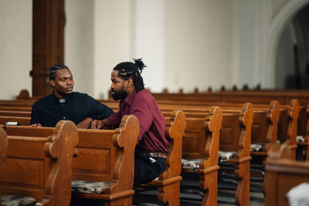 istock Two men sitting in church pew talking about religion 2181726532