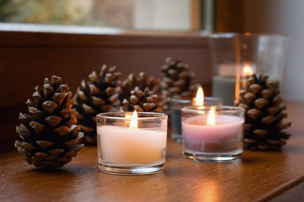 istock Lovely candles and pine cones on the table, cozy home interior 2181726807