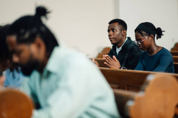 istock Congregation praying with priest leading in church service 2181729058