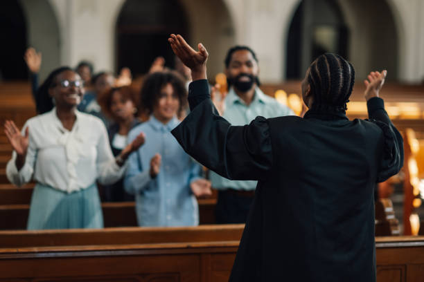 istock Preacher leading congregation in prayer inside church 2181729090