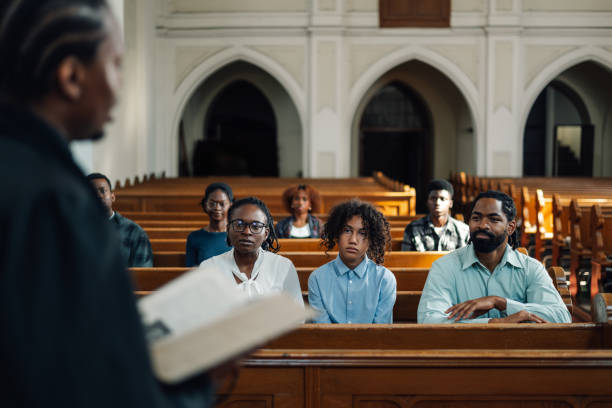 istock Priest holding bible giving sermon to congregation in church 2181729094
