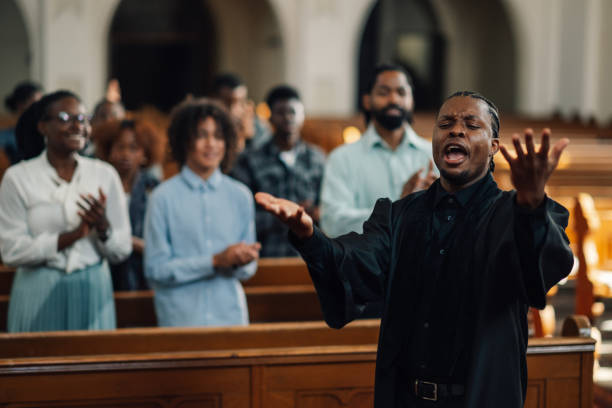 istock Pastor raising hands while preaching to congregation in church 2181729103
