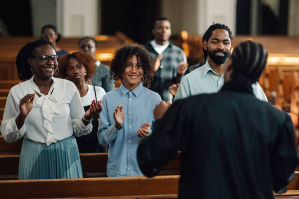 istock Congregation clapping and singing in church pew 2181729134