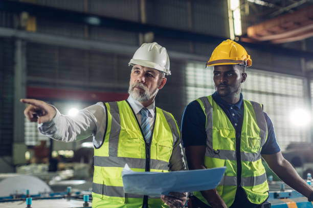 istock Foreman or worker work at factory site check up machine or products in site. 2181731985