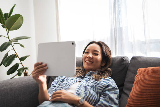 istock Relaxed woman enjoying her tablet on a comfortable sofa 2181733007