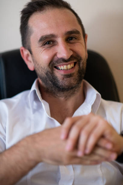 A businessman talking on his smartphone while seated in an office, showcasing his professional demeanor and active communication