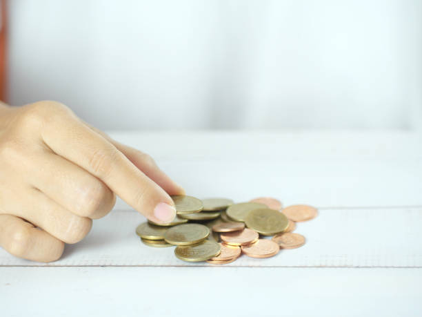 istock Hands counting or holding coins on white table. Business and finance concept. 2181742604