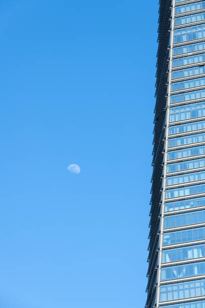 istock white moon and skyscraper in the blue sky 2181743474