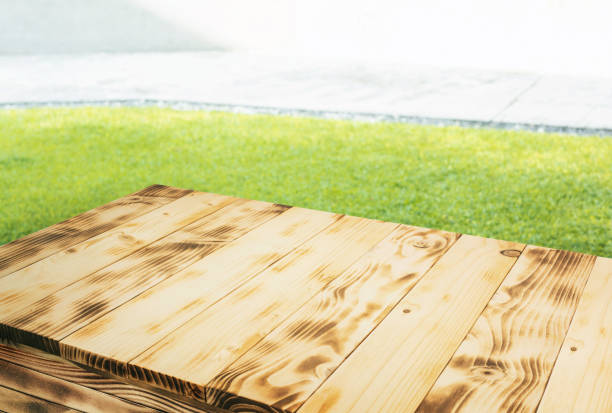 istock Selective focus.Beautiful pine wood texture table top or counter island with green grass lawn background. 2181746113