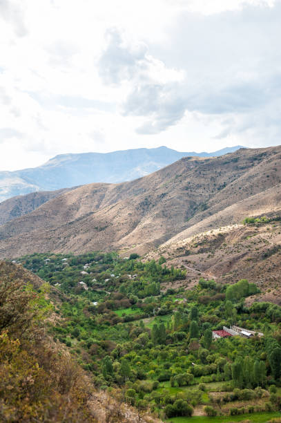 istock Serene valley landscape with lush greenery nestled between hills 2181746130