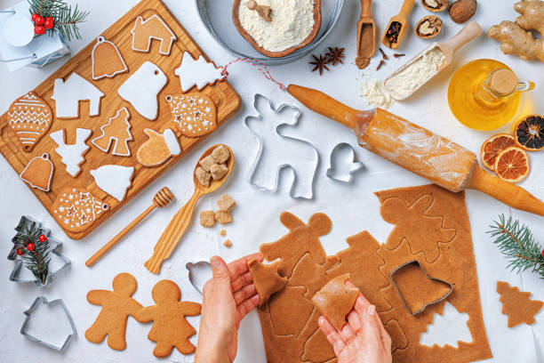 istock Christmas gingerbread different shaped with ingredients for gingerbread and the hands of a woman baker, top view, flat lay 2181749695