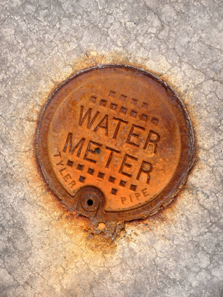 istock Rusted Water Meter Cover Texture on Concrete Sidewalk 2181750468