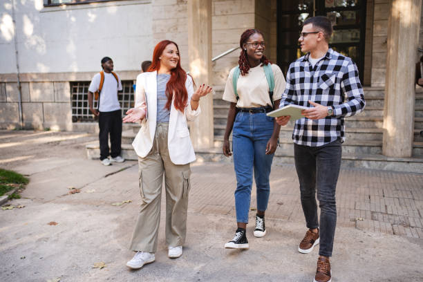 istock Students engage in lively discussion outside their university on a sunny afternoon, showcasing camaraderie and enthusiasm for learning 2181751402