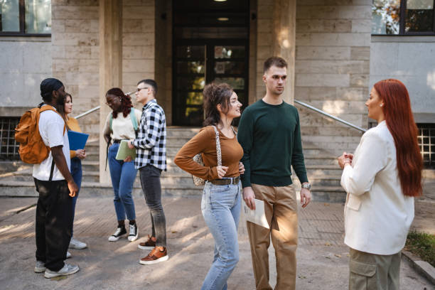 istock Students engaging in lively conversations outside a university building as the afternoon sun casts a warm glow 2181751787